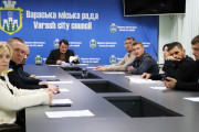 На фото зображено засідання виконачого комітету Вараської міської ради. Засідання відбувається за довгим столом у приміщенні з синім фоном, на якому розміщено герб та напис українською та англійською мовами: "Вараська міська рада / Varash city council". Очолює засідання перший заступник міського голови Павло Павлишин.